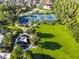 Aerial shot of community tennis courts and playground, surrounded by lush greenery and residential homes at 8030 Hampton Lake Dr, Tampa, FL 33647