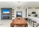 Modern dining room with wood table and an open view to the kitchen at 8250 Velda Trl, Sarasota, FL 34241