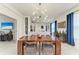 Bright dining room with modern chandelier and hardwood floors at 8250 Velda Trl, Sarasota, FL 34241