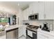 White kitchen with stainless steel appliances and patterned backsplash at 8250 Velda Trl, Sarasota, FL 34241