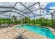 Screened-in pool and spa with lush green backyard views, perfect for relaxation and outdoor entertainment at 8250 Velda Trl, Sarasota, FL 34241