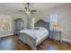 Bedroom featuring a bed with side tables and an armoire on dark wood floors at 9709 Wilderness Trl, Weeki Wachee, FL 34613