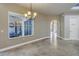 Bright dining room with decorative chandelier, large window and tile floors leading to the pantry at 9709 Wilderness Trl, Weeki Wachee, FL 34613