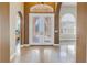 Grand foyer featuring arched doorways, high ceilings, tile flooring and a chandelier at 9709 Wilderness Trl, Weeki Wachee, FL 34613