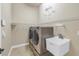 This well-equipped laundry room includes a modern washer and dryer set and a utility sink at 9709 Wilderness Trl, Weeki Wachee, FL 34613