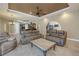 Open-concept living room flows into the kitchen, featuring comfortable seating and a stylish ceiling fan at 9709 Wilderness Trl, Weeki Wachee, FL 34613