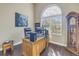 Home office featuring a large desk, dark wood floors, and a large arched window at 9709 Wilderness Trl, Weeki Wachee, FL 34613