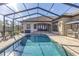 Screened-in pool with brick patio, outdoor dining, and a stainless steel barbecue at 9709 Wilderness Trl, Weeki Wachee, FL 34613