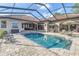 Relax by the screened-in pool with ample lounge space, outdoor kitchen and lush greenery at 9709 Wilderness Trl, Weeki Wachee, FL 34613