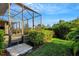 Landscaped backyard with lush greenery and a screened lanai at 5341 Greenbrook Dr, Sarasota, FL 34238