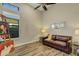 Relaxing sitting area with brown leather couch, wood floors, and large window at 5341 Greenbrook Dr, Sarasota, FL 34238