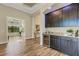 Dark wood wet bar with wine cooler and granite top at 5341 Greenbrook Dr, Sarasota, FL 34238