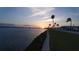 Stunning sunset over calm water, palm trees lining a grassy waterfront at 10315 Cortez W Rd # 5H, Bradenton, FL 34210