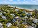 Aerial view of a luxurious beachfront home with a private pool and ocean views at 107 Maple Ave, Anna Maria, FL 34216