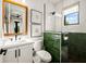 Modern bathroom with green tile accents and a glass-enclosed shower at 107 Maple Ave, Anna Maria, FL 34216