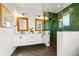 Elegant bathroom with double vanity, frameless shower, and green tile at 107 Maple Ave, Anna Maria, FL 34216