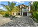 Luxury beachfront home with palm trees and a paved driveway at 107 Maple Ave, Anna Maria, FL 34216