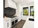 Modern kitchen with stainless steel appliances and dark backsplash at 107 Maple Ave, Anna Maria, FL 34216