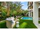 Backyard with pool, lounge seating, and lush landscaping at 107 Maple Ave, Anna Maria, FL 34216