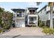 Two-story home with a white exterior, blue accents, and a paved driveway at 110 46Th St, Holmes Beach, FL 34217