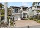 Two-story home with white exterior, balconies, and brick driveway at 110 46Th St, Holmes Beach, FL 34217