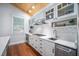 White kitchen with chevron backsplash, stainless steel appliances, and wood floors at 110 46Th St, Holmes Beach, FL 34217