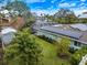 Rear view of a well maintained home featuring solar panels, screened in porch and lush green lawn at 121 Holly Ave, Sarasota, FL 34243