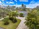 Beautifully landscaped home featuring a paver driveway, solar panels, and lush tropical foliage, enhancing curb appeal at 121 Holly Ave, Sarasota, FL 34243