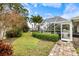 Lush backyard featuring a screened-in pool and outdoor kitchen at 121 Holly Ave, Sarasota, FL 34243