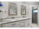 Bathroom featuring a double sink vanity with granite countertops and decorative framed mirrors at 121 Holly Ave, Sarasota, FL 34243