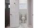 Bright bathroom featuring a toilet, tiled floor, and partially visible shower with decorative stones at 121 Holly Ave, Sarasota, FL 34243