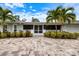 Charming home entrance featuring a brick paver driveway, screened porch and tropical landscaping at 121 Holly Ave, Sarasota, FL 34243