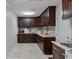 Spacious laundry room featuring dark wood cabinets, marble counters and tile flooring at 121 Holly Ave, Sarasota, FL 34243