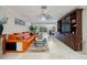 Open-concept living room with a large built-in cabinet and orange leather sectional sofa at 121 Holly Ave, Sarasota, FL 34243