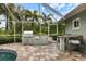 Covered outdoor kitchen and dining area next to the screened pool at 121 Holly Ave, Sarasota, FL 34243