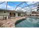 Screened-in pool with brick paver patio and in-ground spa surrounded by lush landscaping at 121 Holly Ave, Sarasota, FL 34243