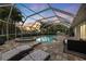 Screened in pool with brick pavers and patio seating, and luscious landscaping at 121 Holly Ave, Sarasota, FL 34243