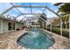 Screened-in pool with brick paver patio and in-ground spa surrounded by lush landscaping at 121 Holly Ave, Sarasota, FL 34243