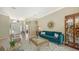 Elegant living room with teal velvet sofa and glass-top coffee table at 12471 Natureview Cir, Bradenton, FL 34212