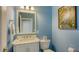 Charming powder room with light blue walls and marble vanity at 12471 Natureview Cir, Bradenton, FL 34212