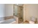 Bathroom featuring marble countertop, bathtub, glass shower, and toilet at 1350 Main St # 1410, Sarasota, FL 34236