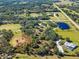 Wide aerial view showcasing the property and surrounding landscape at 13995 Mossy Hammock Ln, Myakka City, FL 34251