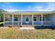 Spacious front porch with stone flooring and white railings at 13995 Mossy Hammock Ln, Myakka City, FL 34251