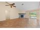 Living room with fireplace, tile floors, and pool access at 13995 Mossy Hammock Ln, Myakka City, FL 34251