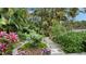 Lush tropical garden with a path, diverse plants, and a tranquil atmosphere at 1423 Kimlira Ln, Sarasota, FL 34231