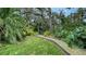 Landscaped garden path winds through lush greenery and tropical plants at 1423 Kimlira Ln, Sarasota, FL 34231