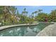 Freeform pool with stone deck and tropical surroundings at 1423 Kimlira Ln, Sarasota, FL 34231