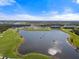 Aerial view of a community with a lake, golf course, and resort-style amenities at 17505 Opal Sand Dr # 108, Venice, FL 34293