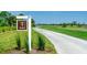 Landscaped golf course with paved cart path and signage at 17505 Opal Sand Dr # 108, Venice, FL 34293