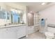 Bathroom boasts a granite vanity, tub shower combo, and white cabinetry at 18017 Gawthrop Dr # 101, Bradenton, FL 34211